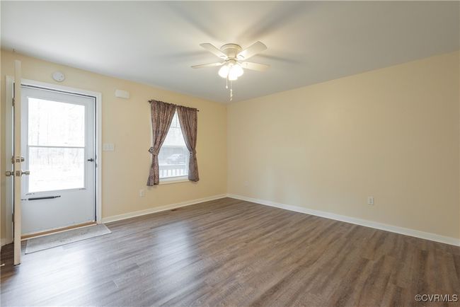 Unfurnished room with baseboards, dark wood-style flooring, and a ceiling fan | Image 6