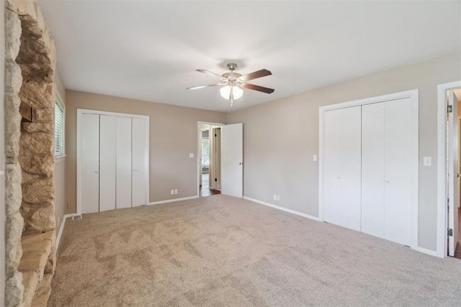 Unfurnished bedroom with two closets, carpet floors, and a ceiling fan | Image 25
