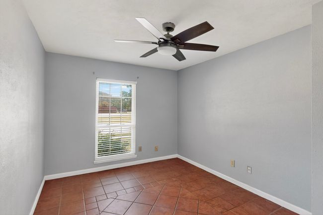 Tiled empty room with a ceiling fan and baseboards | Image 12