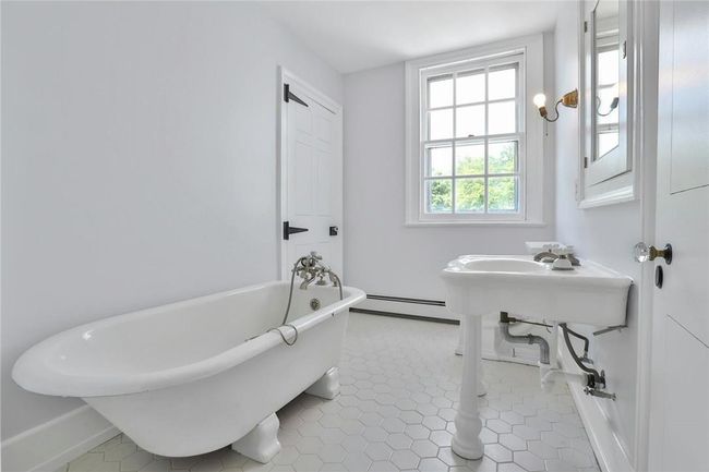 Refurbished hall bath with clawfoot soaker tub and original pedestal vanity | Image 24