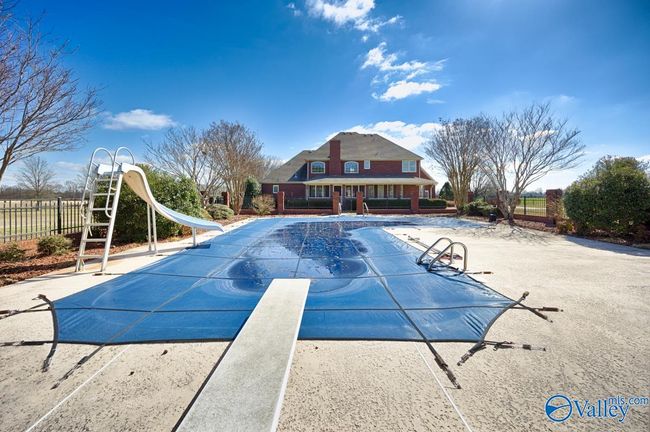 Cool-deck concrete pool surround, back of house, view from pool house, landscaping around pool | Image 44