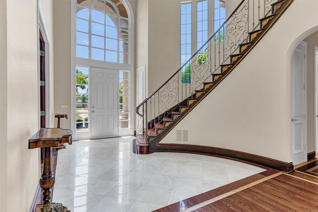 The foyer reveals enchanting views of the curved staircase with ornate wrought iron baluster and gold medallion accents plus an abundance of windows for natural light! | Image 4