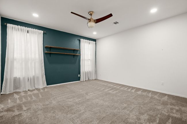 Unfurnished bedroom with carpet flooring, recessed lighting, ceiling fan, and visible vents | Image 9