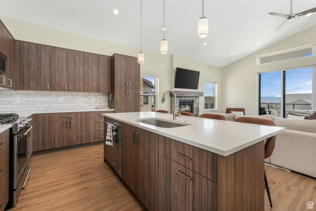 The spacious kitchen, featuring a gas range and generous countertop space, flows seamlessly into the living room, creating an open and inviting atmosphere that leads out to a serene balcony, perfect for both cooking and entertaining. | Image 23