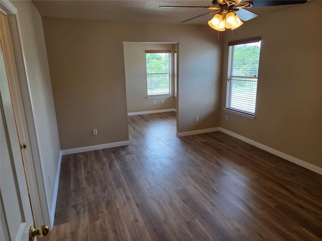 Empty room featuring a ceiling fan and dark wood-style floors | Image 27