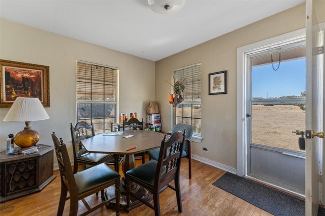 Dining room with wood finished floors, a healthy amount of sunlight, and baseboards | Image 6