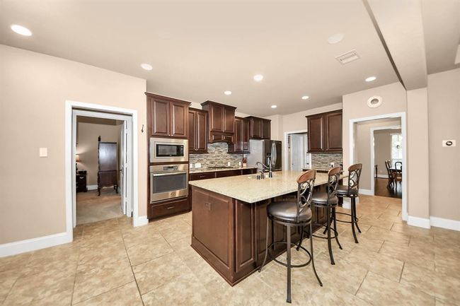 The large island gives additional seating space and storage cabinets all around. | Image 9