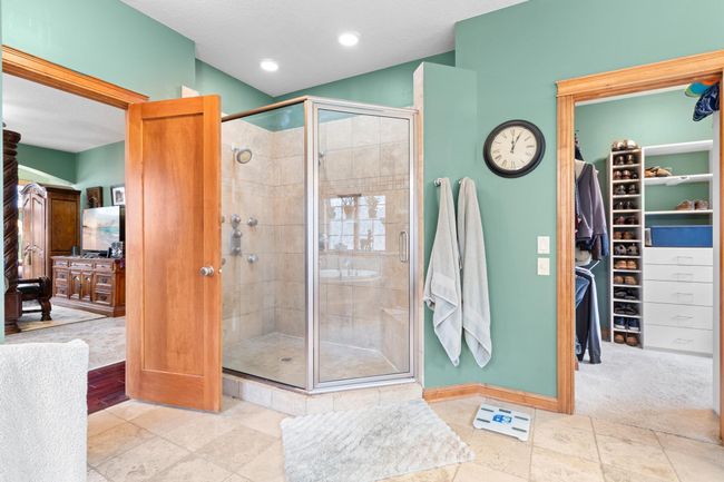 Primary bath. Custom tile shower with dual showers and controls. Tile sitting bench in shower. | Image 26