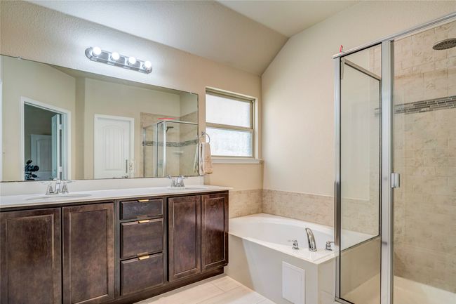 Full bathroom with a shower stall, double vanity, a bath, and a sink | Image 26