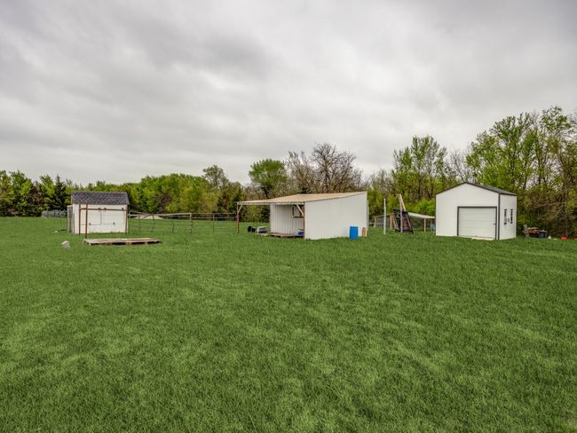 View of yard with an outbuilding, a garage, and fence | Image 19