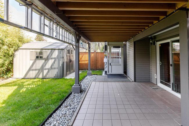 View of patio featuring an outbuilding, a storage unit, elevator and fence | Image 10