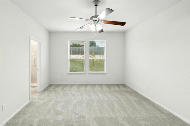 The primary suite is tucked away downstairs for added privacy, complete with new carpet, an ensuite bathroom and generous walk-in closet. | Image 10
