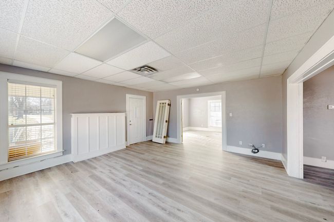 Unfurnished room with light wood-type flooring and a drop ceiling | Image 8