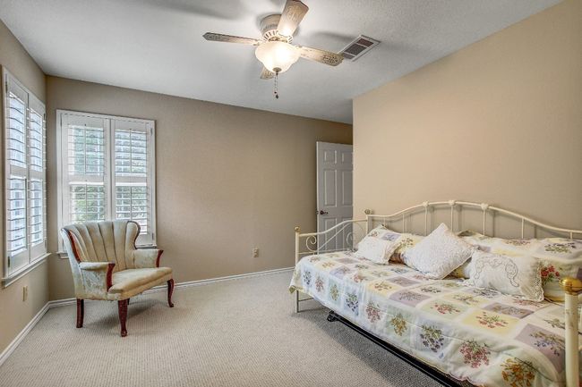 Carpeted bedroom featuring baseboards, a ceiling fan, and visible vents | Image 27