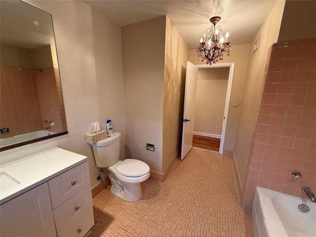 Full bathroom with vanity, a notable chandelier, tile patterned flooring, shower combination, and toilet | Image 15