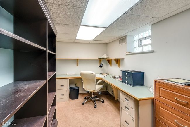 Basement office featuring light carpet, a paneled ceiling | Image 27
