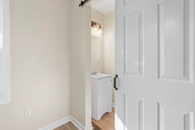 Corridor featuring light wood finished floors and a barn door | Image 22