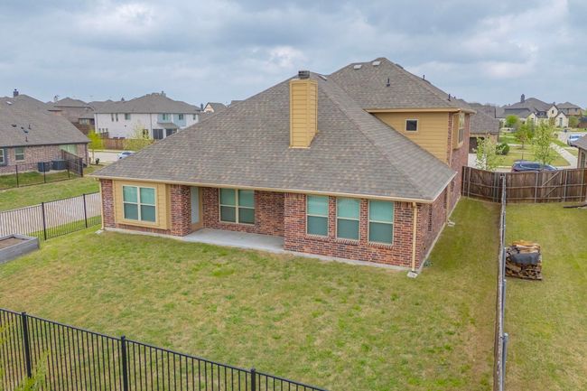 Back of house with a lawn, a shingled roof, a patio area, and brick siding | Image 16