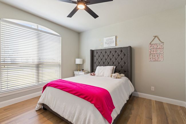 Bedroom featuring wood finished floors, a ceiling fan, and baseboards | Image 20