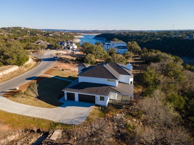 An aerial view showcases this architectural gem, perfectly positioned to capture breathtaking panoramic views of Lake Travis and the Hill Country in Jonestown. Thoughtfully designed for both elegance and functionality, this home seamlessly blends luxury with the beauty of its natural surroundings. | Image 36