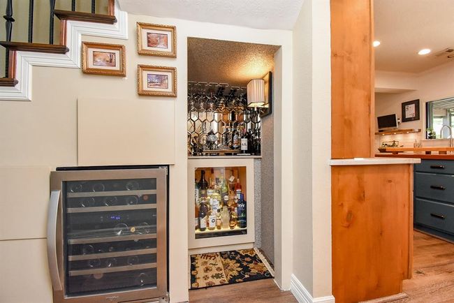 Located just off the kitchen is this wonderful bar area. The bar features a pull out liquor drawer, an elegant way to display your finest liquors. Look close to see the drawers built into the wall under the stairs. | Image 22