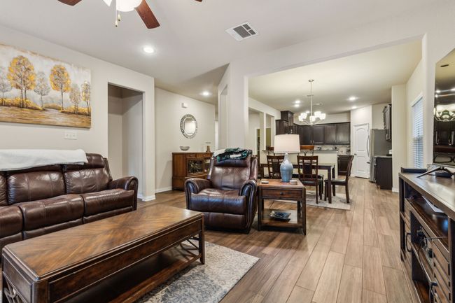 Living room featuring a ceiling fan, wood finished floors, a chandelier, recessed lighting, and baseboards | Image 5