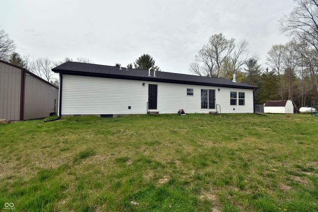 back of property featuring a yard, a pole barn, and a storage unit | Image 47