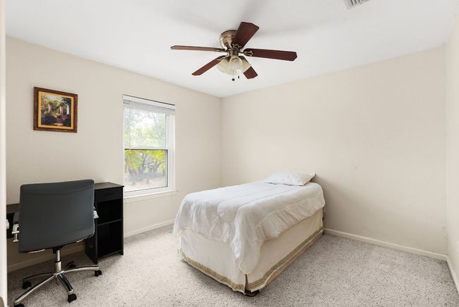 Bedroom featuring light colored carpet, ceiling fan, and baseboards | Image 23
