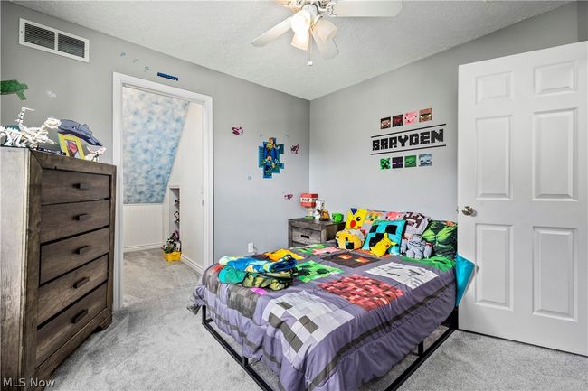 Bedroom featuring ceiling fan, a textured ceiling, and light carpet | Image 29