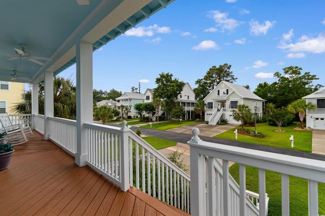 Porch with a residential view, ceiling fan, and a lawn | Image 34