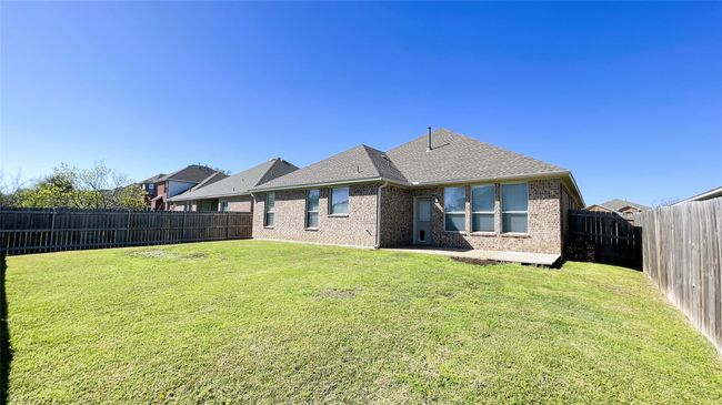 Rear view of house featuring a fenced backyard, brick siding, a shingled roof, and a patio | Image 33