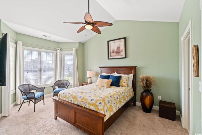 Bedroom featuring light colored carpet, lofted ceiling, and a ceiling fan | Image 7