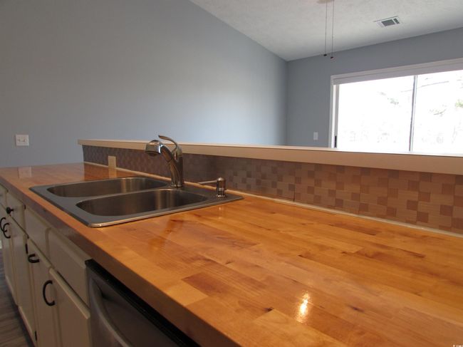 Kitchen with butcher block countertops, white cabinets, a double bay sink. | Image 26