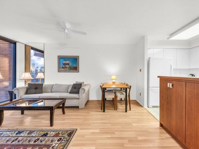 Living room with a ceiling fan and light wood-style floors | Image 4