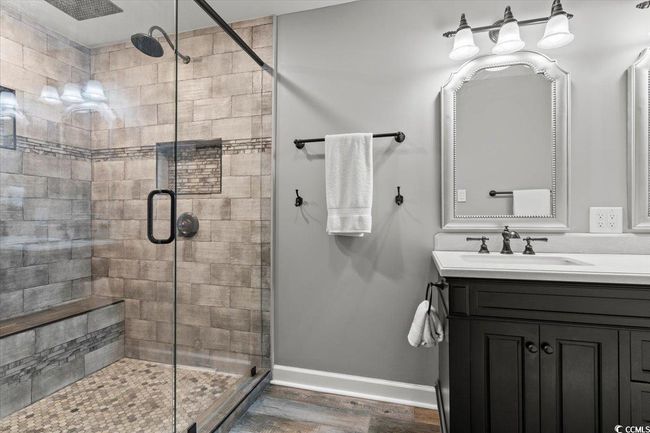 Full bath with a shower stall, wood finished floors, baseboards, and vanity | Image 21