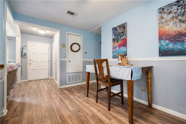 Dining room with baseboards, wood finished floors, and visible vents | Image 12