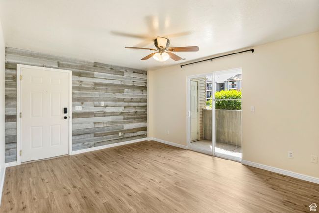 Spare room featuring a ceiling fan, an accent wall, baseboards, and wood finished floors | Image 4