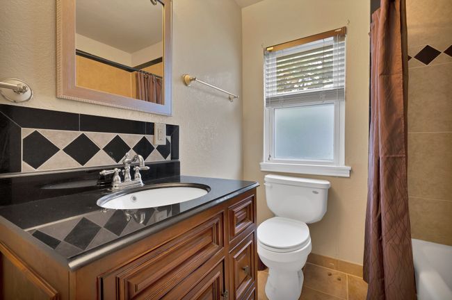 Full bathroom with vanity, decorative backsplash, tile patterned floors, and toilet | Image 18