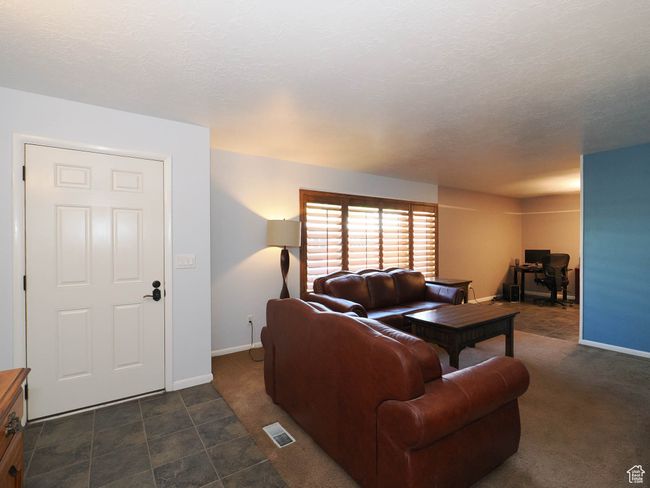 Living room featuring baseboards and dark carpet | Image 4