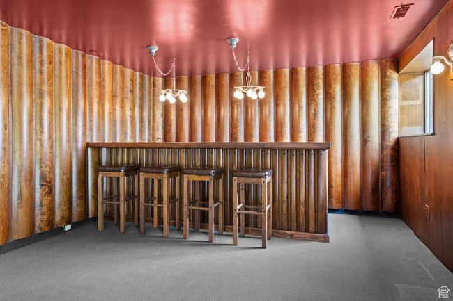 Bar area featuring carpet flooring and a chandelier | Image 31