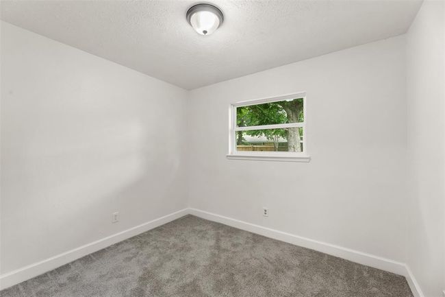 Cozy, well-lit second bedroom with fresh paint and flooring. | Image 19