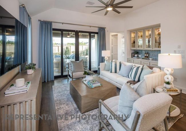 Living room featuring a ceiling fan, wood finished floors, and lofted ceiling | Image 10