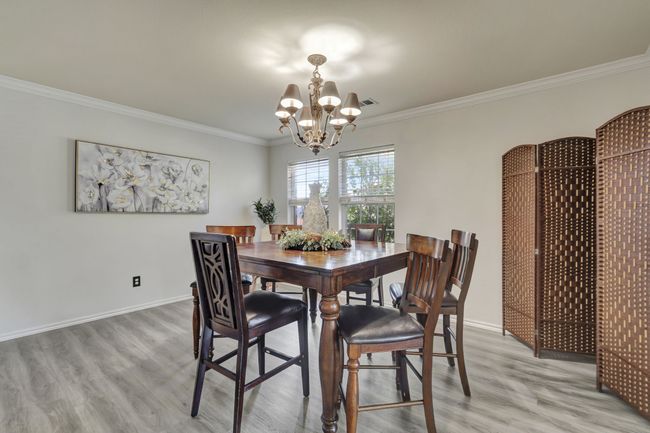 Dining area with ornamental molding, hardwood / wood-style floors, and an inviting chandelier | Image 9