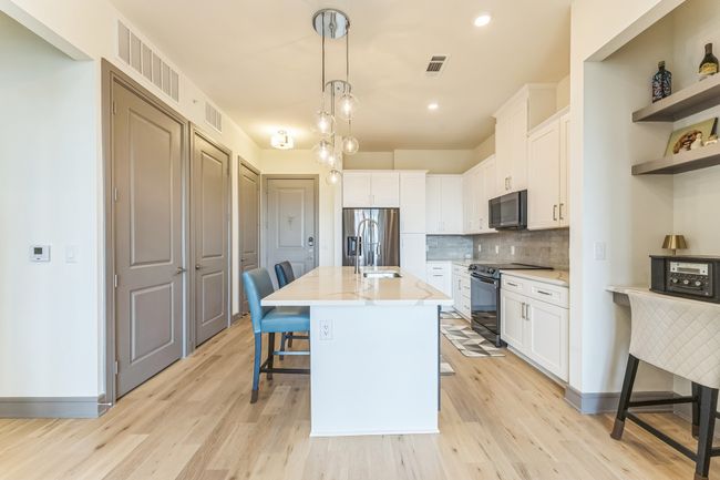 Kitchen featuring decorative backsplash, electric stove, white cabinetry, open shelves, and recessed lighting | Image 13