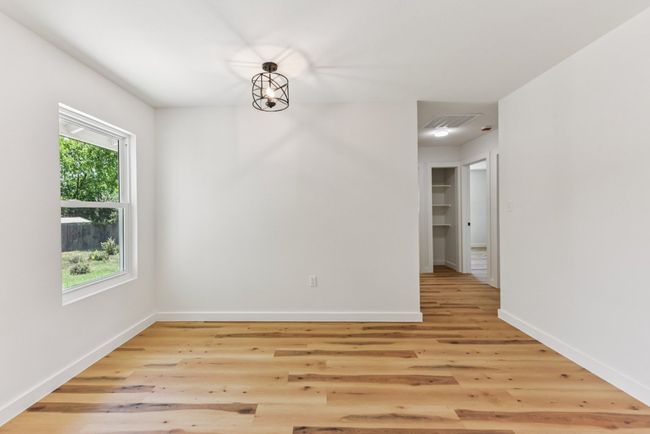 Spare room with light wood finished floors and a chandelier | Image 14