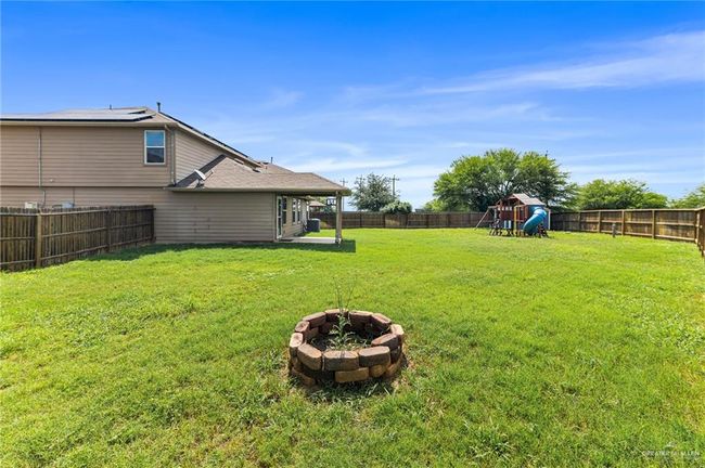 Fenced backyard featuring an outdoor fire pit and a playground | Image 29