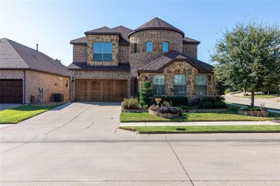 View of front facade with a garage, central AC unit, and a front lawn | Image 1