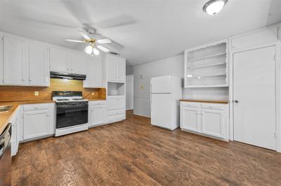 Kitchen with ceiling fan, white cabinets, white appliances, and a textured ceiling | Image 3