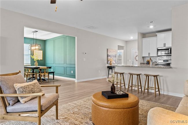 Living room featuring light wood-type flooring, baseboards, a ceiling fan, a chandelier, and recessed lighting | Image 23
