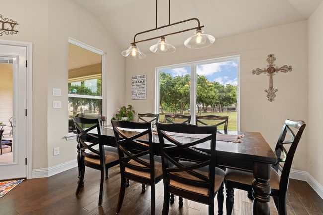 Dining space featuring lofted ceiling and dark wood finished floors | Image 12